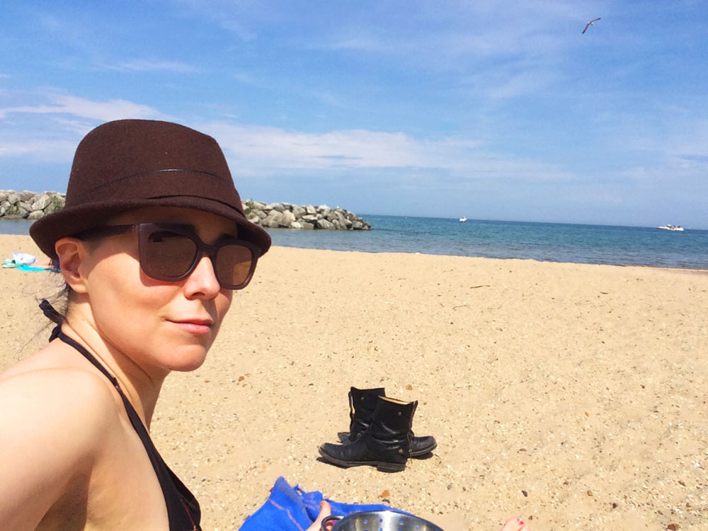 erica in sunglasses and German hat at the beach by Lake Michigan